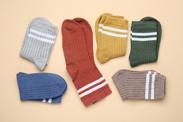 Many different pairs of socks on beige background, flat lay