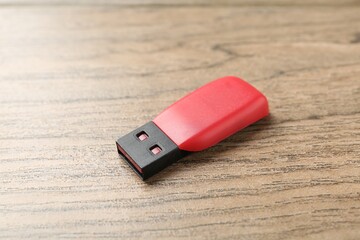 One flash drive on wooden background, closeup