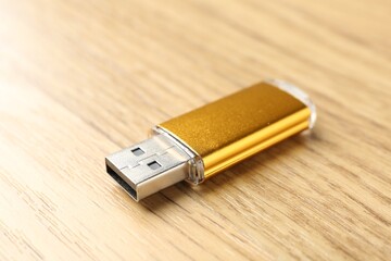 One flash drive on wooden background, closeup. Space for text