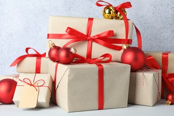 Many gift boxes wrapped in kraft paper and Christmas decor on light table