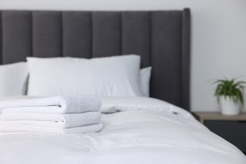 Clean terry towels on bed at home, space for text