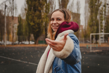 A young woman explores an urban park during an overcast day, surrounded by towering buildings and...