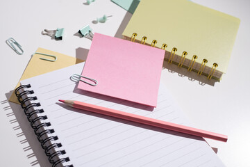 Office or school supplies. Notepad, clips, paper clips and sticky notes, pencils and markers on a colored background.