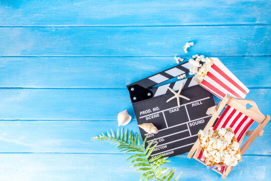 Summer holiday and vacation movie cinema marathon background Cinema clapper-board with sunglasses, seashells, starfish, popcorn buckets, vacation accessories, Cinema for the summer Movie Night party