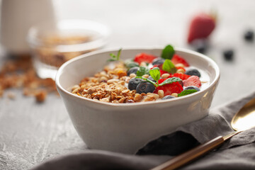 Homemade crispy granola, yogurt and berries in bowl on white background. Healthy breakfast
