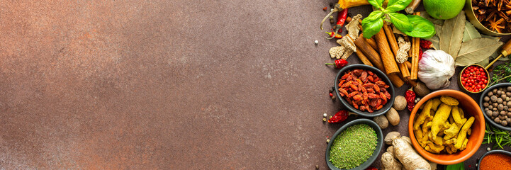 A visually striking arrangement of fresh spices and herbs on a brown surface, highlighting their vivid colors, intricate details, and rich culinary essence, banner