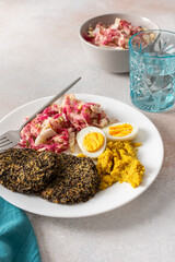 A nutritious breakfast featuring quinoa pancakes, fresh cabbage, radish, mung bean sprouts, boiled eggs, hummus, and roasted beets, perfect for a balanced start to your day