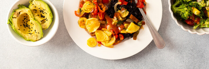 A nutritious and delicious breakfast plate featuring black rice with stewed vegetables, fresh...