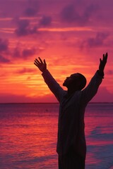 Fototapeta premium Businessman raising arms at sunset on beach celebrating success