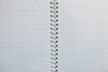 Open notebook in a cage on a metal spiral with clean pages, top view, notebook