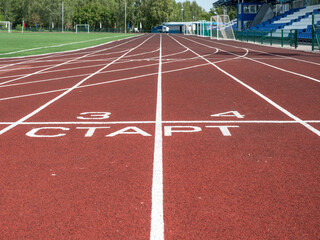 Red treadmill at the stadium with white lines