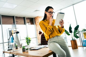 Professional businesswoman analysis tablet data in a modern office environment showcasing...