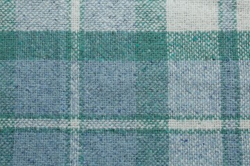 Fototapeta premium Turquoise woolen fabric with geometrical pattern as background, top view