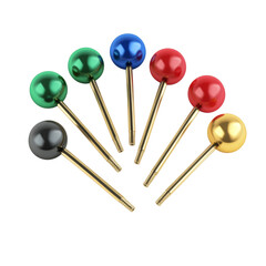 Array of multi colored spherical headed pins, creating a playful and vibrant arrangement against simple studio setting