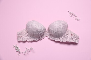 Lace bra and decorative elements on pink background, flat lay