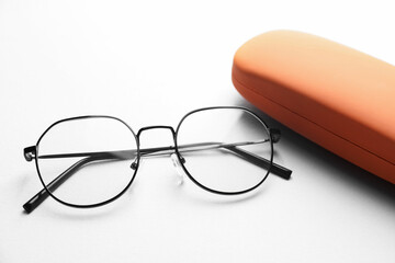 Case with stylish glasses on light background, closeup