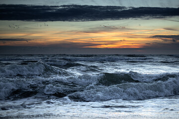 Stormy Sea Under Fiery Sunset Horizon with Crashing Waves
