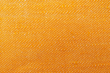 Texture of dense yellow fabric for tailoring. Canvas. Textile. Material