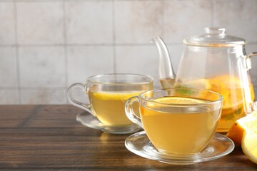 Aromatic fruit tea with orange and lemon on wooden table, closeup. Space for text