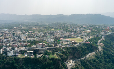 A city surrounded by mountains and hills and the visible roads are making the view very beautiful