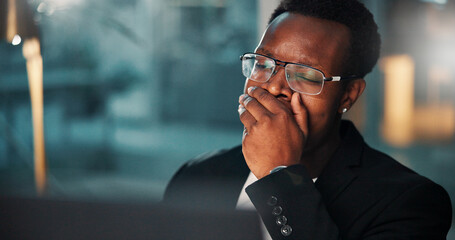 Black man, tired and night with yawn, computer and burnout for evening deadline at office desk....