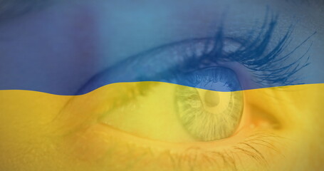 Image of flag of ukraine waving over open eye of caucasisan woman