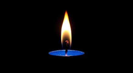 A single blue candle burns brightly against a black background