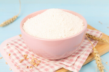 Bowl with spelt flour on wooden table
