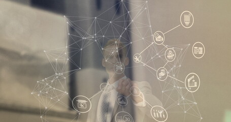 Image of network of connections with icons over caucasian businessman