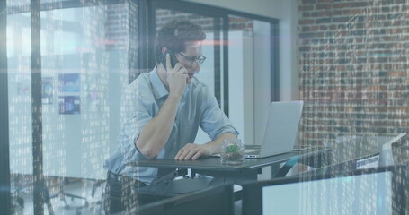 Image of glowing light over caucasian businessman using technology