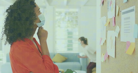 Image of data processing over businesswomen wearing face masks