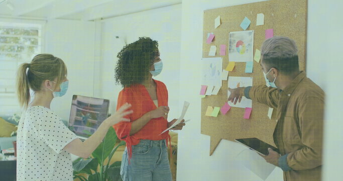 Image of data processing over businesswomen wearing face masks