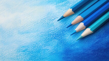 Four blue colored pencils on blue watercolor paper.