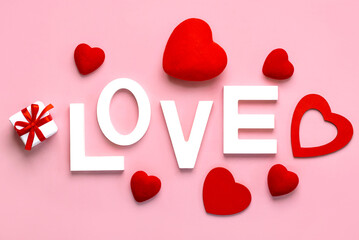 The word love in white wooden with a red hearts and gift box. Valentine's day celebration and Mother's Day concept