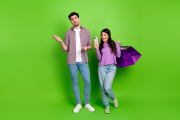 Fototapeta premium Smiling young couple enjoying leisure moments against a vibrant green backdrop, symbolizing modern lifestyle and friendship