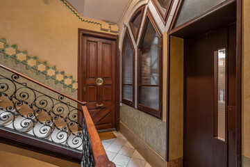 Elegant stairway with ornate wrought iron railings and wooden doors in a classic interior
