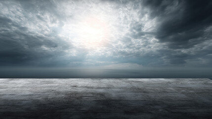 Obraz premium A concrete platform faces a dramatic, overcast sky with sunlight breaking through dark clouds creating an evocative and atmospheric seascape background scene.