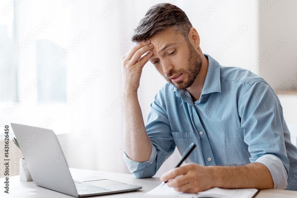Poster busy businessman taking notes to notepad while working with laptop at office, planning business sche
