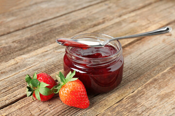 Delicious strawberry sauce and fresh berries on wooden table, closeup