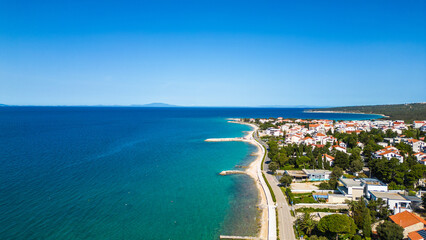 Fototapeta premium Aerial view of Novalja on Pag Island, Croatia. Famous for its beaches, vibrant summer atmosphere, and scenic Adriatic coastline. Captured by drone for a stunning panoramic perspective