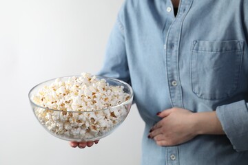 Woman refusing to eat popcorn on white background, closeup. Food allergy concept