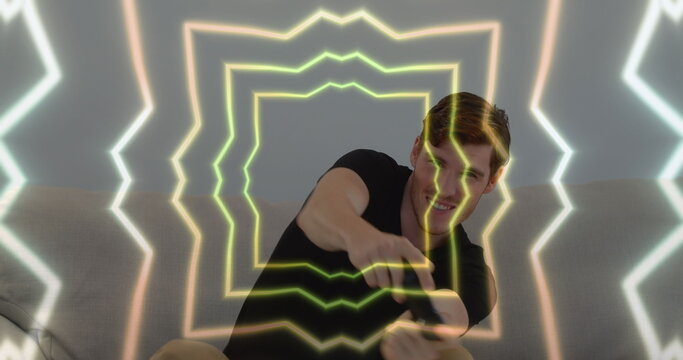 Image of tunnel with neon shapes over caucasian man playing image games