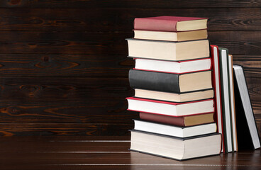 Stack of old books on wooden table, space for text