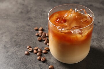 Tasty iced coffee and beans on grey table, closeup. Space for text