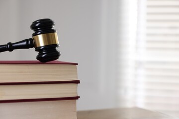 Judge's gavel and books on table indoors, closeup
