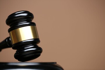 Judge's gavel and sound block on pale brown background, closeup. Space for text