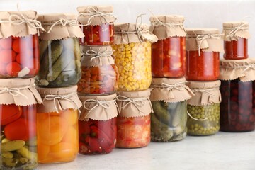 Many jars with different pickled products on light table