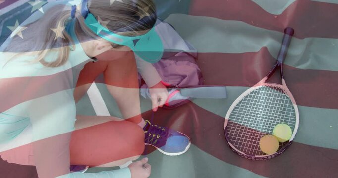 Female tennis player kneeling tying laces beside racket balls on court showing sports metrics