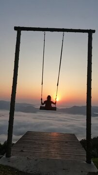 mulher andando em balan&ccedil;o com nascer do sol ao fundo e mar de nuvens no horizonte. V&iacute;deo feito no morro s&atilde;o Bernardo, em Rio dos Cedros, Santa Catarina