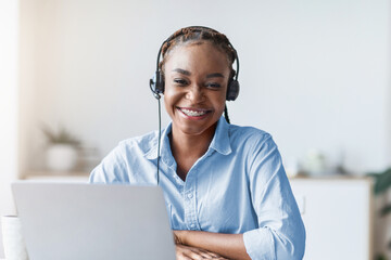 Portrait Of Smiling Black Woman Call Center Operator At Workplace In Office, Sitting At Desk With...
